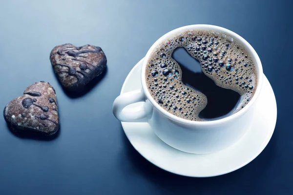 Weiße Tasse schwarzen Kaffee mit Keksen auf dunklem Hintergrund — Stockfoto
