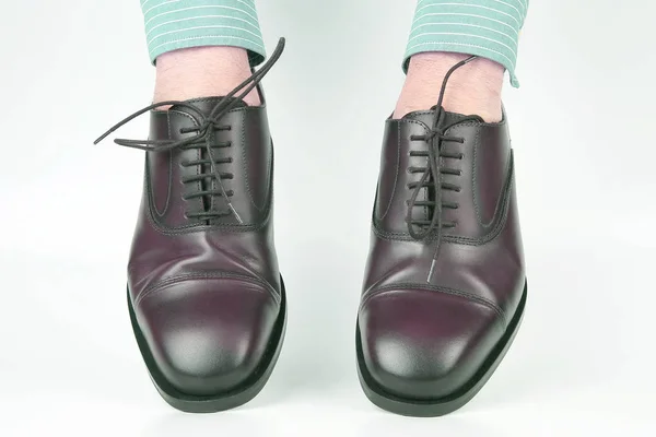 Klassieke bruine schoenen gedragen op de handen op een witte achtergrond — Stockfoto