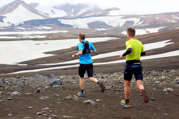 Dwaj sportowcy biegaczy biegowi góralską w ośnieżonych terenach — Zdjęcie stockowe