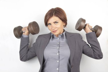 Takım elbiseli mutlu iş kadını dambılları kaldırıyor