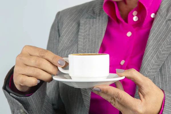 Business woman drinks coffee from a white cup close-up