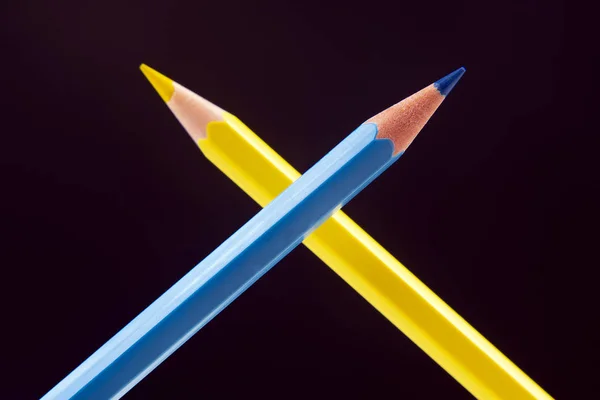 Modré a žluté tužky pro kreslení na tmavém pozadí. Vzdělávání — Stock fotografie