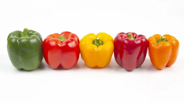 Peperoni colorati su sfondo bianco. cibo vitaminico — Foto Stock