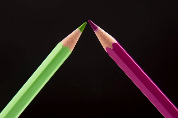 Green and pink pencils for drawing on a dark background. Educati — Stock Photo, Image