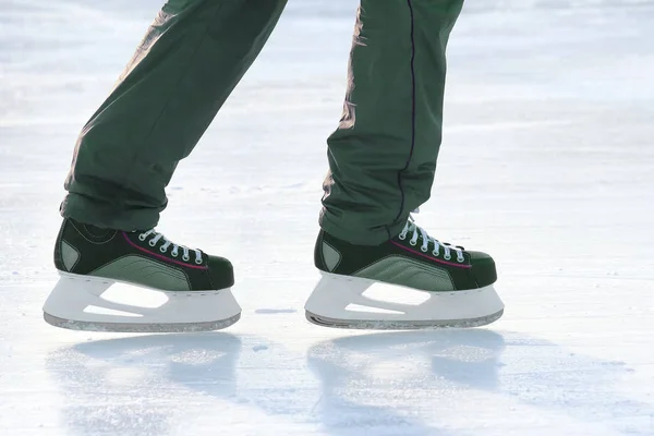 Die Beine eines Mannes, der auf der Eisbahn Schlittschuh läuft. Sport und Unterhaltung — Stockfoto