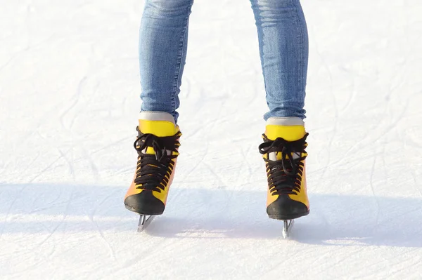 Vrouwelijke benen in schaatsen op een ijsbaan. Sport en amusement. R — Stockfoto