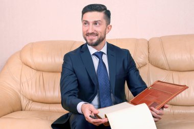 Başarılı bir iş adamı üzerine oturduğu iş belgeleriyle meşgul.