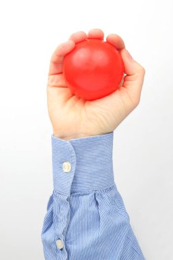 Erkek el beyaz arka planda kırmızı bir top tutuyor.