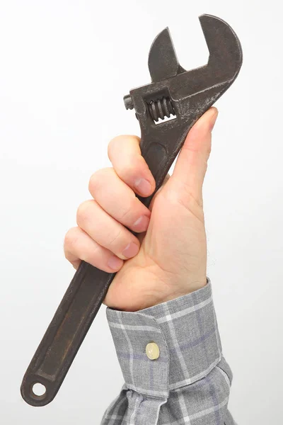 Αρσενικό χέρι κρατά ένα γαλλικό κλειδί σε λευκό φόντο — Φωτογραφία Αρχείου