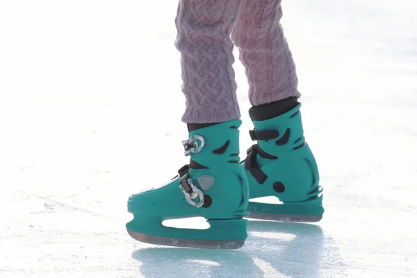 Frauenbeine in blauem Schlittschuhlaufen auf der Eisbahn. Sport und Unterhaltung — Stockfoto