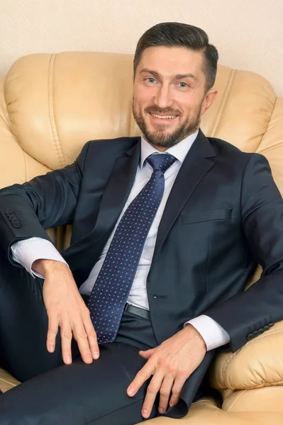 bir deri kanepede oturan başarılı iş adamı