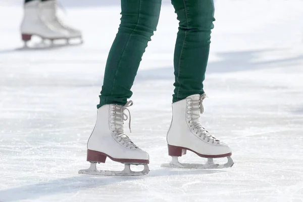 Voeten meisje schaatsen op ijs rin schaatsen — Stockfoto