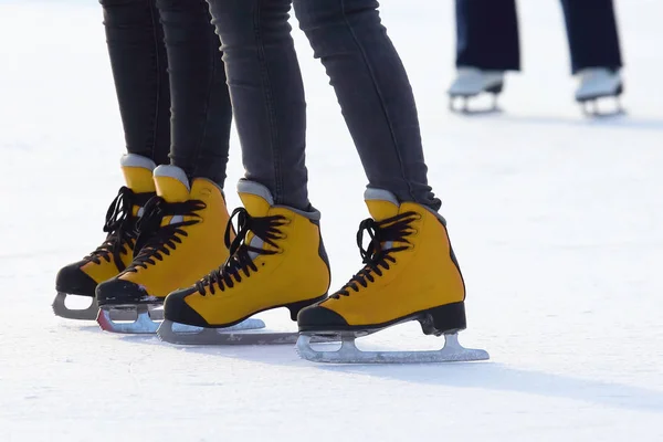 Női lábak korcsolyáznak a jégpályán. Sport és szórakozás. — Stock Fotó