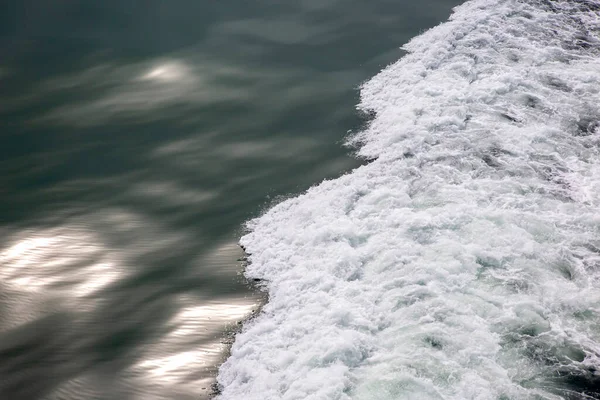 the waves from the ship on the background of the tranquil ocean