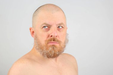 Hafif arka planda sakallı bir adamın portresi.