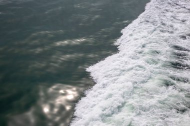 Sakin okyanusun arka planındaki gemiden gelen dalgalar.