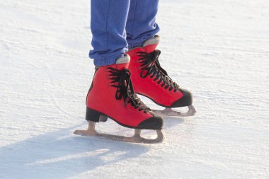 Buz pistinde kırmızı paten giyen ayaklar. Hobiler ve boş vakitler. kış sporları