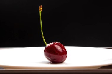 Sulu kiraz böğürtlenleri beyaz bir tabakta yatıyor. Kahvaltıda sağlıklı yemek. Bitkilerin meyveleri. meyve tatlısı