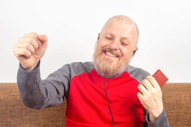 Sakallı adam evde en sevdiği müziği küçük kulaklıklı bir ses çalarla dinlemeyi sever. işitsel ve müzik aşığı. müzik ve hi-fi ses