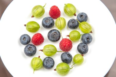 Beyaz tabakta çeşitli taze meyveler var. Sağlıklı meyve vitamini. sağlıklı sebze kahvaltısı