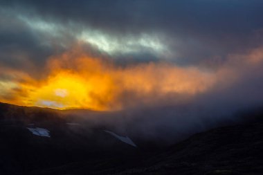 İzlanda 'nın dağlık ve sisli arazisinde gün batımı. Doğa ve yerler harika seyahatler için