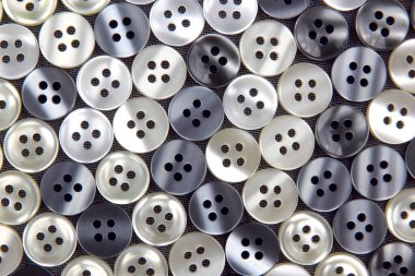 Kumaş arka plandaki kıyafetler için plastik parlak düğmeler. Moda ve giysi. Fabrika endüstrisi