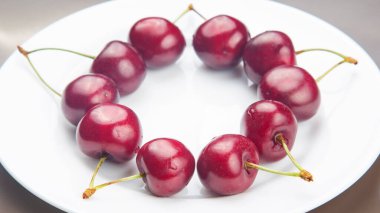 Sulu kiraz böğürtlenleri beyaz bir tabakta yatıyor. Kahvaltıda sağlıklı yemek. Bitkilerin meyveleri. meyve tatlısı