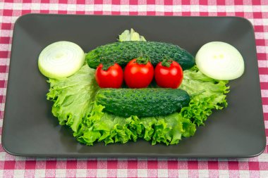 Taze salatalık, domates ve gri tabakta marul. Vitaminler ve hafif kahvaltı.