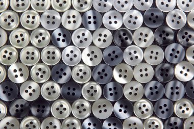 Kumaş arka plandaki kıyafetler için plastik parlak düğmeler. Moda ve giysi. Fabrika endüstrisi