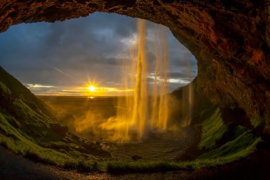 Seljalandsfoss şelalesine karşı parlak bir günbatımı. Icelan