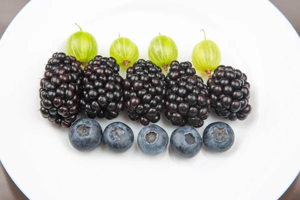 Beeren Blaubeeren Stachelbeeren Und Brombeeren Auf Einem Weißen Teller Nützliches — Stockfoto