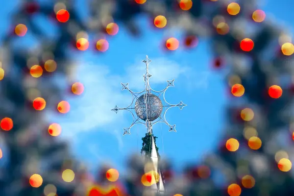 在五颜六色的装饰的模糊背景上 一棵新年街上的树的顶部 — 图库照片