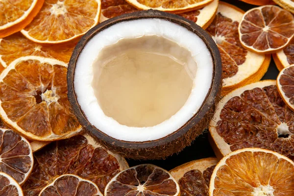 coconut with natural milk on a background of dried citrus fruits