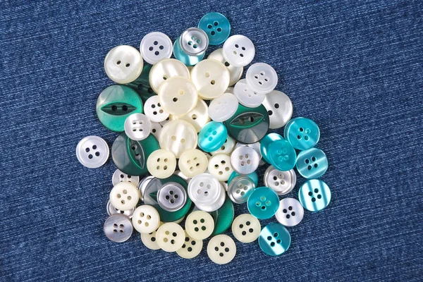 Plastic shiny buttons for clothes on a fabric background. Fashion and clothing. Factory industry