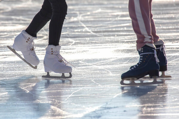 people ice skating on an ice rink. hobbies and leisure. winter sports