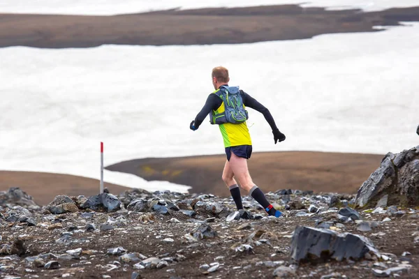 athlete runners run a mountain marathon in the snowy terrain of Landmannalaugar. Iceland