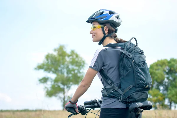 Beautiful and happy girl cyclist with a bike on nature. Healthy lifestyle and sports. Leisure and hobbies