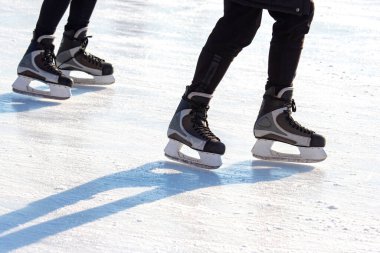Buz pateni pistinde kayan bir adamın bacakları. Hobiler ve spor. Tatiller ve kış aktiviteleri