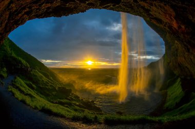 Seljalandsfoss şelalesine karşı parlak bir günbatımı. Icelan