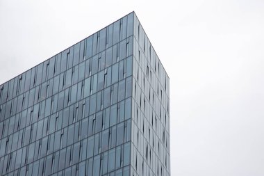 Gökyüzüne karşı çok katlı modern bir binanın cam cephesi