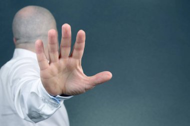 Adam olumsuz el hareketi yaptı ve sırtını döndü.