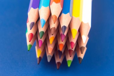 Koyu mavi arka plan üzerine çizim yapmak için renkli kalemler. Eğitim ve yaratıcılık. Boş zaman ve sanat