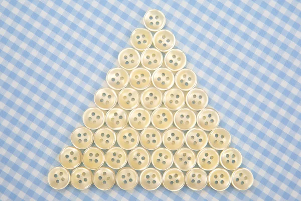 Plastic shiny buttons for clothes on a fabric background. Fashion and clothing. Factory industry