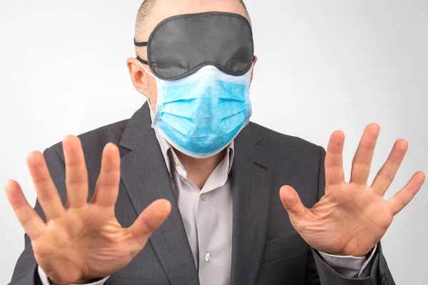白い背景で手を上げて眠る医療用マスクと目隠しをしたビジネスマン — ストック写真