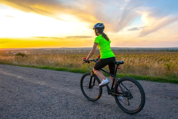 Schöne Radfahrerin Auf Dem Fahrrad Auf Der Straße Richtung Sonnenuntergang — Stockfoto