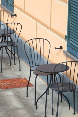 İtalya 'da geleneksel evin yanında demir bahçe masası ve sandalyeler. Bahçe mobilyası. Yaz bahçesi aranjmanı. Yüksek kalite fotoğraf