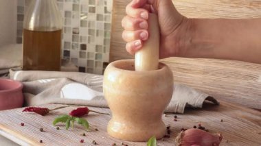 İsimsiz biri mutfaktaki mermer havanda baharat öğütür. Yemek ve yemek. Sağlıklı beslenme ve organik ürünler. Yüksek kalite 4k görüntü