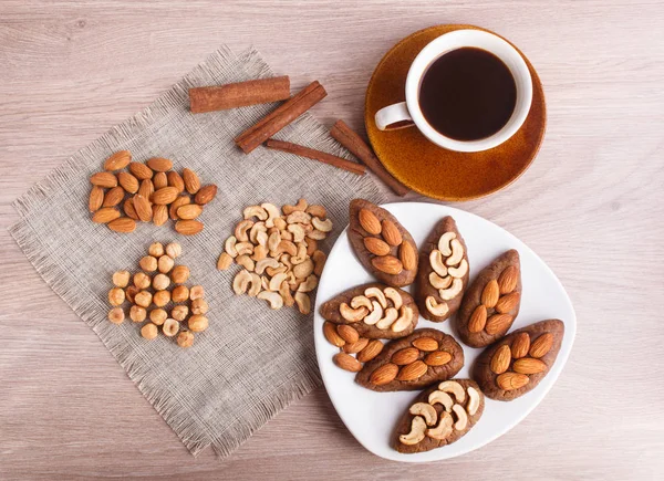 Small cakes "potatoes" with almonds and cashew nuts.  A cup of c — Stock Photo, Image