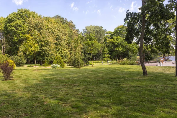 Alter Park mit grünen Rasenflächen und großen Bäumen. — Stockfoto