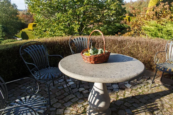 garden furniture, stone table with a basket with decorative pump